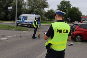 Zdjęcie przedstawiające policjantów, radiowóz oraz uszkodzony pojazd.