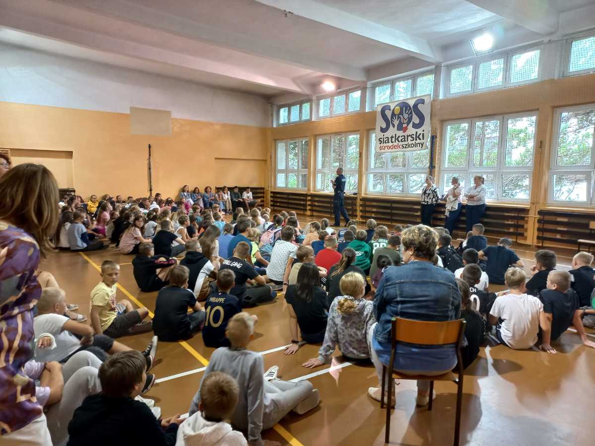 Zdjęcie przedstawiające policjanta przemawiającego do dzieci.