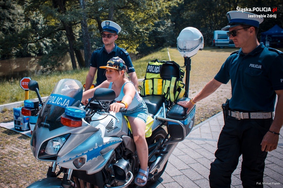 Zdjęcie przedstawiające policjantów i dziecko na motorze.