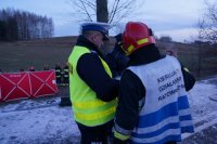 Fotografia kolorowa. Na zdjęciu widać policjanta z Wydziału Ruchu Drogowego oraz Dowódcę Działań Ratowniczych.