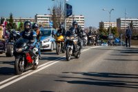 Fotografia kolorowa. Przedstawia uczestników przejazdu motocyklowego oraz policjantów zabezpieczających to wydarzenie.