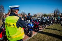 Fotografia kolorowa. Przedstawia uczestników przejazdu motocyklowego oraz policjantów zabezpieczających to wydarzenie.