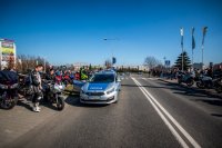 Fotografia kolorowa. Przedstawia uczestników przejazdu motocyklowego oraz policjantów zabezpieczających to wydarzenie.