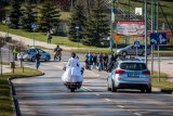 Fotografia kolorowa. Przedstawia uczestników przejazdu motocyklowego oraz policjantów zabezpieczających to wydarzenie.