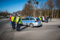 Fotografia kolorowa. Przedstawia uczestników przejazdu motocyklowego oraz policjantów zabezpieczających to wydarzenie.