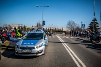 Fotografia kolorowa. Przedstawia uczestników przejazdu motocyklowego oraz policjantów zabezpieczających to wydarzenie.