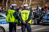 Fotografia kolorowa. Przedstawia uczestników przejazdu motocyklowego oraz policjantów zabezpieczających to wydarzenie.