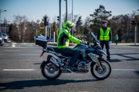 Fotografia kolorowa. Przedstawia uczestników przejazdu motocyklowego oraz policjantów zabezpieczających to wydarzenie.