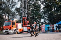 Zdjęcie kolorowe, przedstawiające festyn bezpieczeństwa na którym straż pożarna zaprezentowała swoje pojazdy.