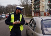 Zdjęcie kolorowe, przedstawiające policjanta ruchu drogowego.