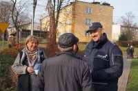 Zdjęcie kolorowe, przedstawiające dzielnicowego i pracowników socjalnych w trakcie kampanii &quot;Biała wstążka&quot;.