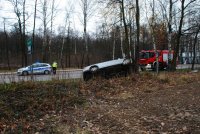 Zdjęcie kolorowe, przedstawiające policjanta i uszkodzony pojazd ford.