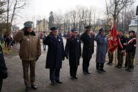 Zdjęcie kolorowe, przedstawiające służby mundurowe przed pomnikiem.