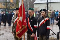 Zdjęcie kolorowe, przedstawiające uczniów z pocztem sztandarowym przy pomniku.