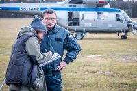 Zdjęcie kolorowe, przedstawiające helikopter SOKÓŁ oraz policjantkę.