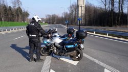 Zdjęcie kolorowe, przedstawiające policjanta na motocyklu.