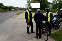 Zdjęcie kolorowe, przedstawiające policjantów i rowerzystę.