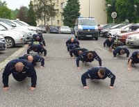 Zdjęcie kolorowe, przedstawiające policjantów wykonujących zadanie sportowe.