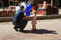 Zdjęcie kolorowe, przedstawiające policjantów z dziećmi.