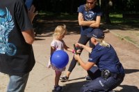 Zdjęcie kolorowe, przedstawiające policjantów z dziećmi.