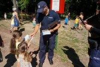 Zdjęcie kolorowe, przedstawiające policjantów z dziećmi.