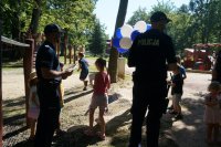 Zdjęcie kolorowe, przedstawiające policjantów z dziećmi.