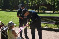 Zdjęcie kolorowe, przedstawiające policjantów z dziećmi.