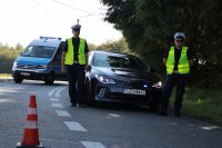 Zdjęcie kolorowe, przedstawiające policjantów zabezpieczających wyścig.