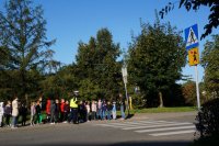 Zdjęcie kolorowe, przedstawiające policjanta ruchu drogowego i dzieci z klasy pierwszej.