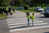 Zdjęcie kolorowe przedstawiające policjanta ruchu drogowego oraz uczestników prelekcji.