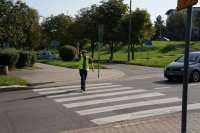 Zdjęcie kolorowe, przedstawiające policjanta na przejściu dla pieszych.