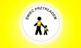 Zdjęcie kolorowe, przedstawiające plakat akcji &amp;quot;Świeć przykładem&amp;quot; na którym są przedstawione dwie postacie w kamizelkach.