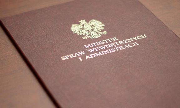 Zdjęcie kolorowe, przedstawiające teczkę z napisem Ministerstwo Spraw Wewnętrznych i Administracji.