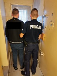 Zdjęcie przedstawiające policjanta oraz zatrzymanego.