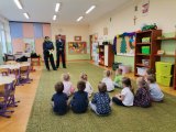 Zdjęcie przedstawiające dzieci i policjantów w przedszkolu.