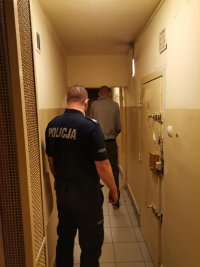 Zdjęcie przedstawiające policjanta i osobę zatrzymaną.