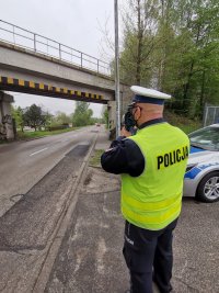 Zdjęcie przedstawiające policjantów dokonujących pomiaru prędkości.