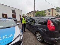 Zdjęcie przedstawiające policjanta i pojazd zatrzymanego kierowcy.