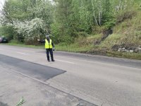 Zdjęcie przedstawiające policjanta, który dokonuje zatrzymania pojazdu.