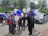 Zdjęcie kolorowe, przedstawiające dzieci oraz policjantów.