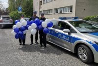 Zdjęcie kolorowe, przedstawiające policjantów z prezentami dla dzieci.