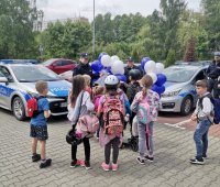 Zdjęcie kolorowe, przedstawiające dzieci w trakcie spotkania z policjantami.