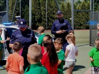 Zdjęcie przedstawiające dzieci na spotakniu oraz policjantów.