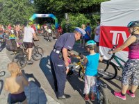 Zdjęcie przedstawiające policjanta ruchu drogowego rozdającego elementy odblaskowe.