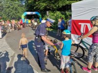 Zdjęcie przedstawiające policjanta ruchu drogowego rozdającego elementy odblaskowe.