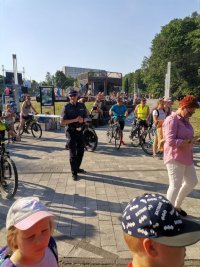 Zdjęcie przedstawiające policjanta ruchu drogowego rozdającego elementy odblaskowe.