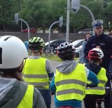 Zdjęcie przedstawiające policjanta ruchu drogowego oraz dzieci zdające kartę rowerową.