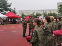 Zdjęcie przedstawiające sztandar i uczniów klas mundurowych w trakcie ślubowania.