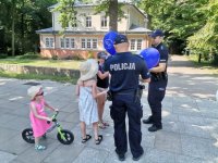 Zdjęcie przedstawiające policjantów oraz dzieci w trakcie przekazywania baloników.
