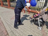 Zdjęcie przedstawiające policjantkę wręczającą balonika.